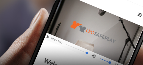 Phone displaying a video with the LeoSafePlay logo.